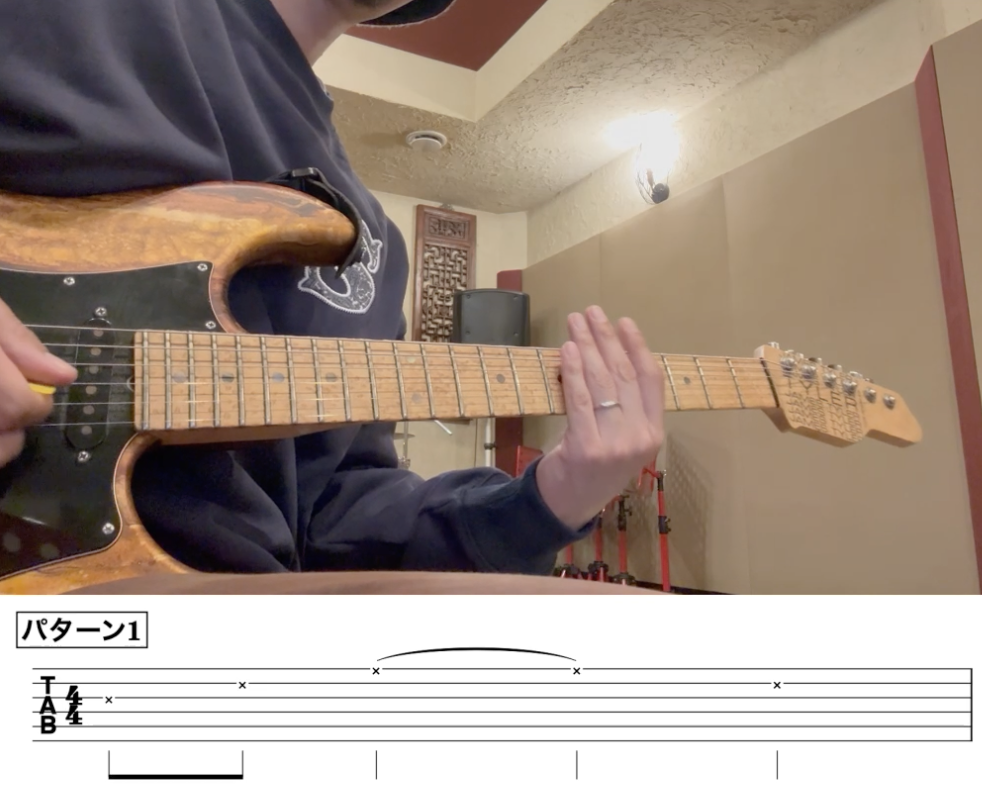 調布のギター教室で講師がアルペジオの練習法を指導している様子。左手で弦をミュートし、ブラッシングで右手のピッキングパターンとリズムを安定させるコツを解説。