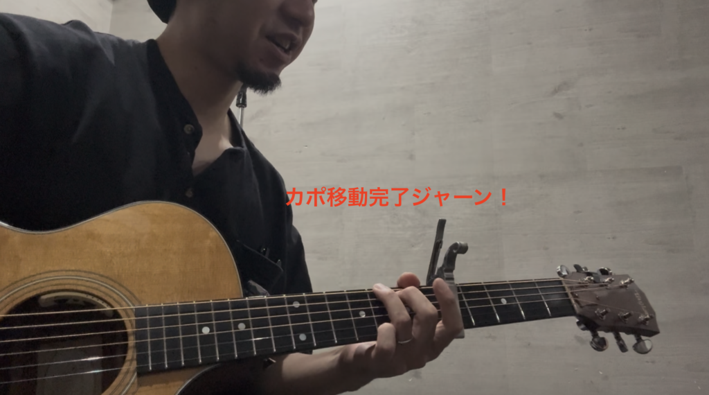 カポ移動後、曲のテンポを崩さずに次のフレーズへスムーズに入る生徒のアコースティックギター演奏風景。
