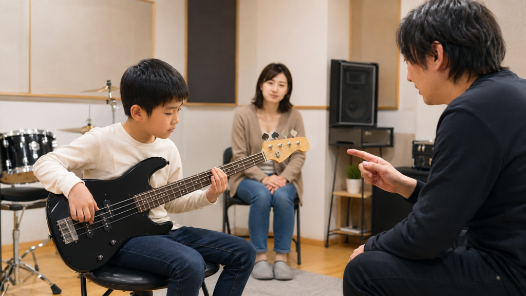 保護者が見守るスタジオで7歳前後の子どもがベースレッスンを受ける様子
