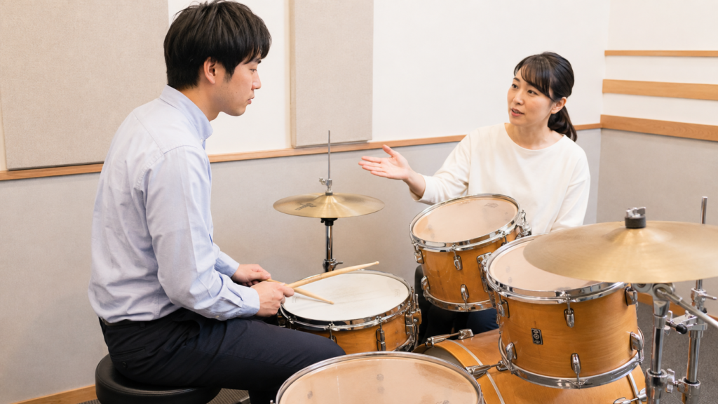 体験レッスンでレンタル用スティックを受け取るドラム初心者