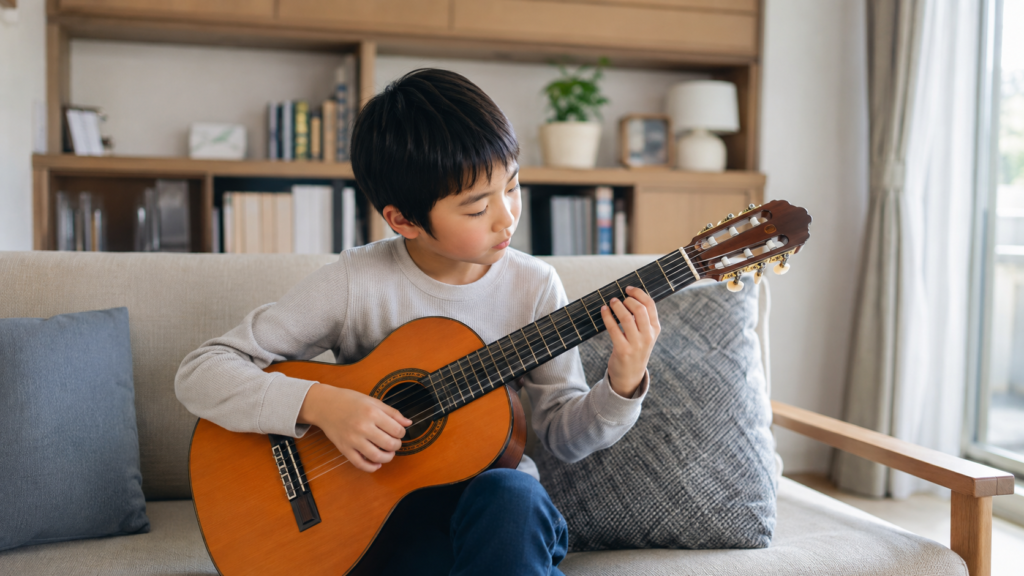 自宅で小学生が小さな音量でギターを練習する様子