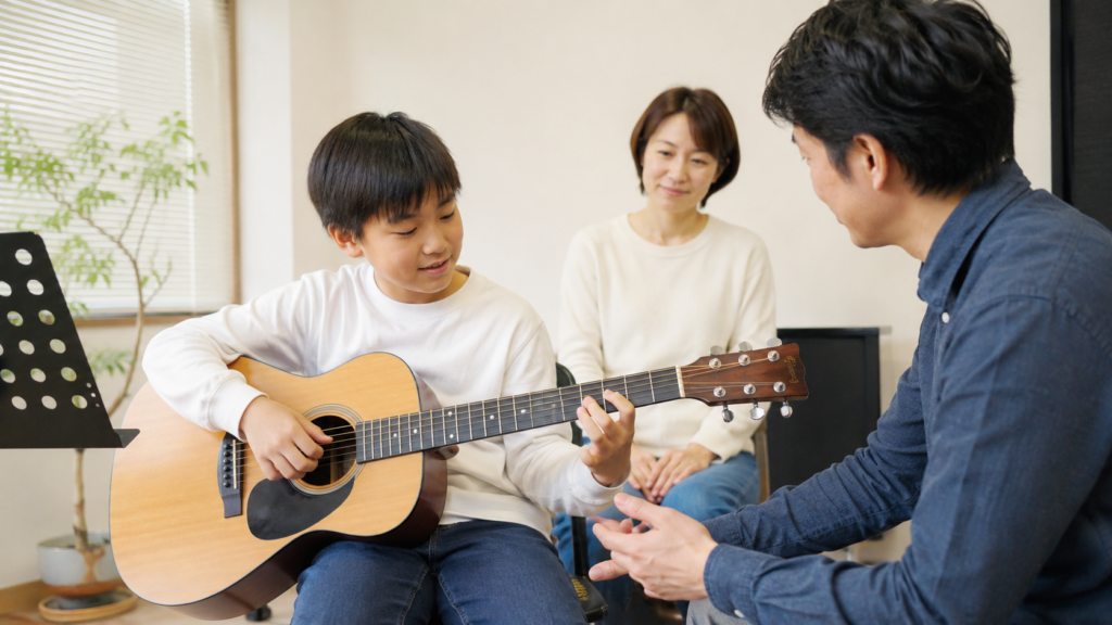 千歳烏山で小学生が保護者とギター体験レッスンを受ける様子