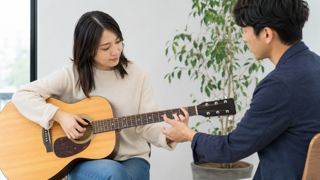 大人の女性初心者が個人ギターレッスンを受ける様子