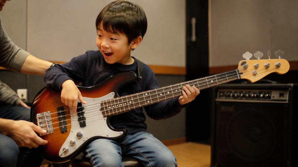 7歳前後の子どもが初めてエレキベースの音を出す様子