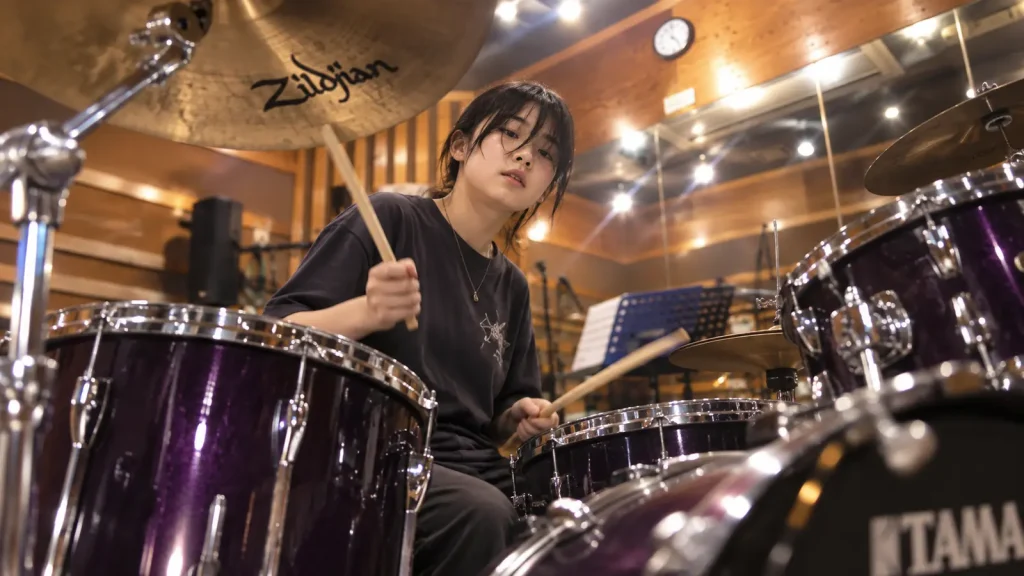 高円寺の音楽スタジオでドラムセットを演奏する中高生