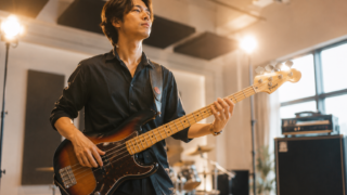 譜面を見ずに前を向いて自信たっぷりにエレキベースを弾くベーシスト