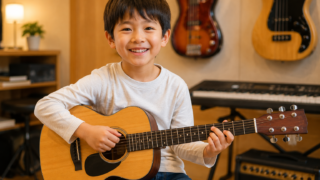 千歳烏山のギター教室で新しい習い事としてギターを始め、笑顔で楽器を持つ小学生の初心者のお子さま。