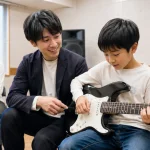 調布で小学生がマンツーマンギターレッスンを受ける様子