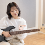 ベース初心者が指弾きとピック弾きのどちらを選ぶか考えている様子