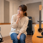 エレキギターとアコースティックギターを前にどちらを選ぶか考える初心者