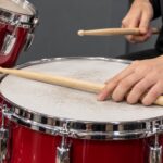 スネアの打面にスティックを沿わせるクローズドリムショットの手元の解説イメージ"